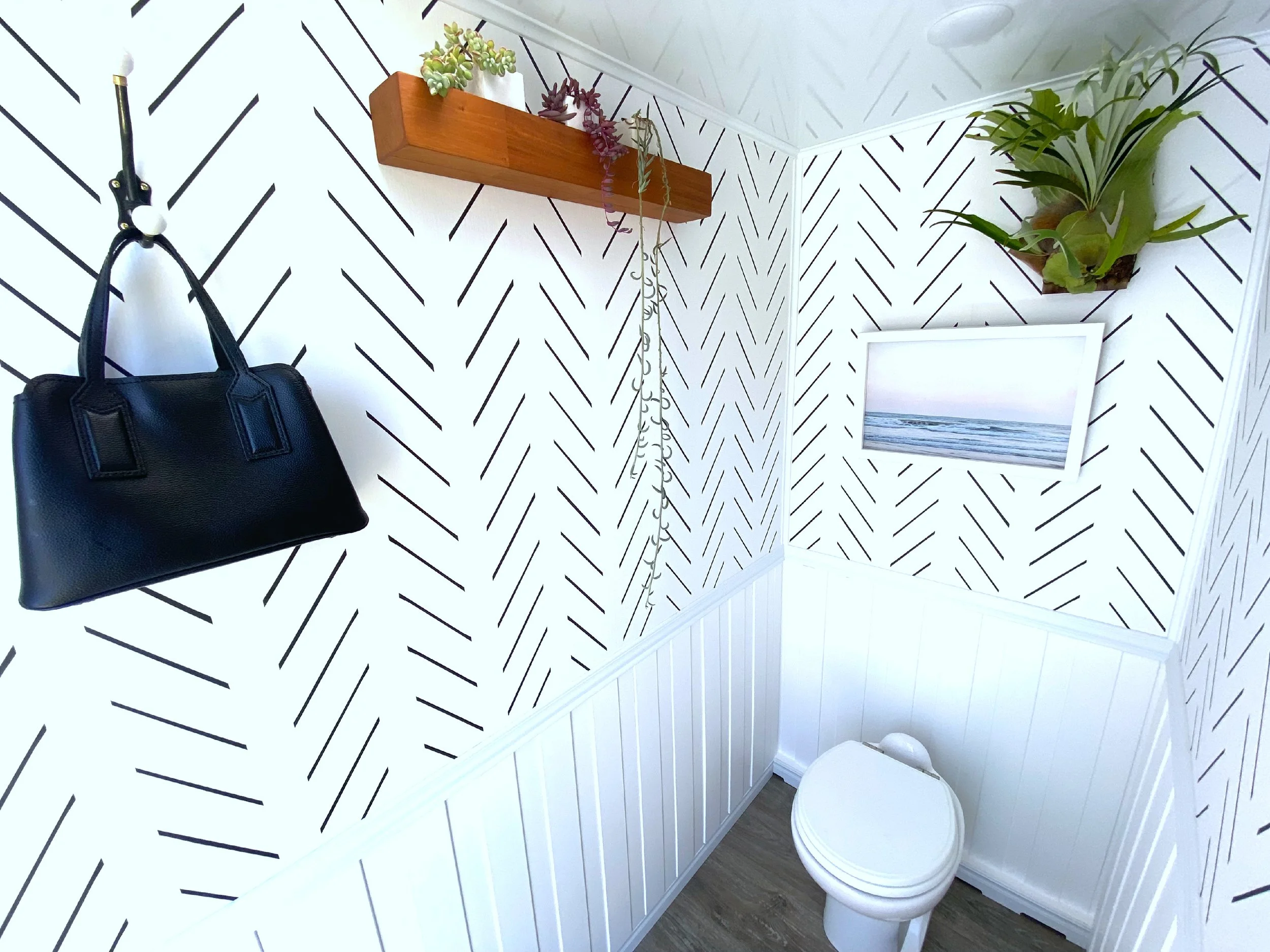 Coastal Modern women's restroom with bag hook